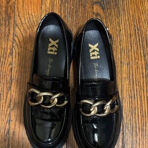 Xti Black Mules with Gold Chain Accent.